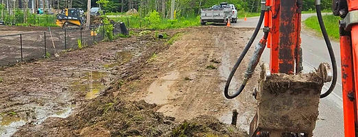 Orange excavator on wet dirt road at North of 12 Contracting worksite, serving Victoria Harbour, Midland, Simcoe County, Georgian Bay & Muskoka