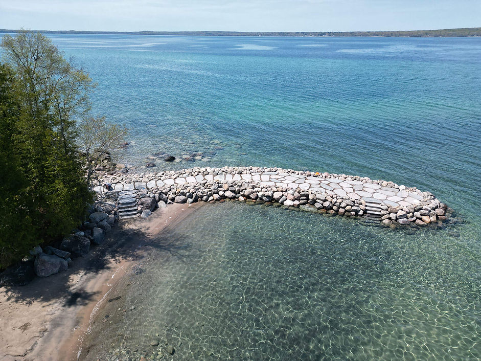 Boulder groyne wall with stone path and steps leading into the lake