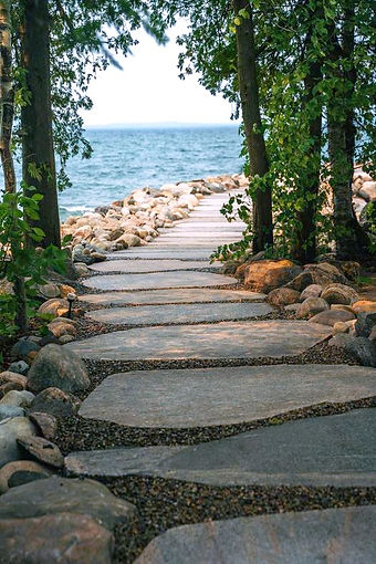 Flagstone pathway through trees leading to the lake, part of Morden Construction’s custom stonework and waterfront access projects in Port Carling.