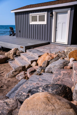 stone steps to boathouse and dock surrounded by natural boulders