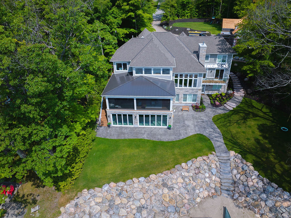 grey brick home with lots of windows and beautiful landscaping