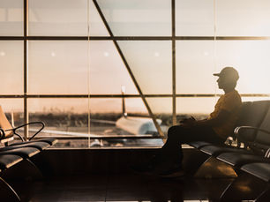 Pessoa triste no aeroporto representando a tristeza em imigrar