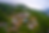 Aerial view of a rustic resort with stone buildings and a pool surrounded by lush green hills and mist. A tranquil, serene atmosphere. Pictured is Blackberry Mountain resort in Walland, Tennessee.