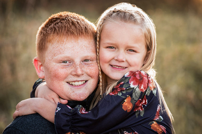 Smiling siblings embrace in a portrait, happy children with Families outdoors