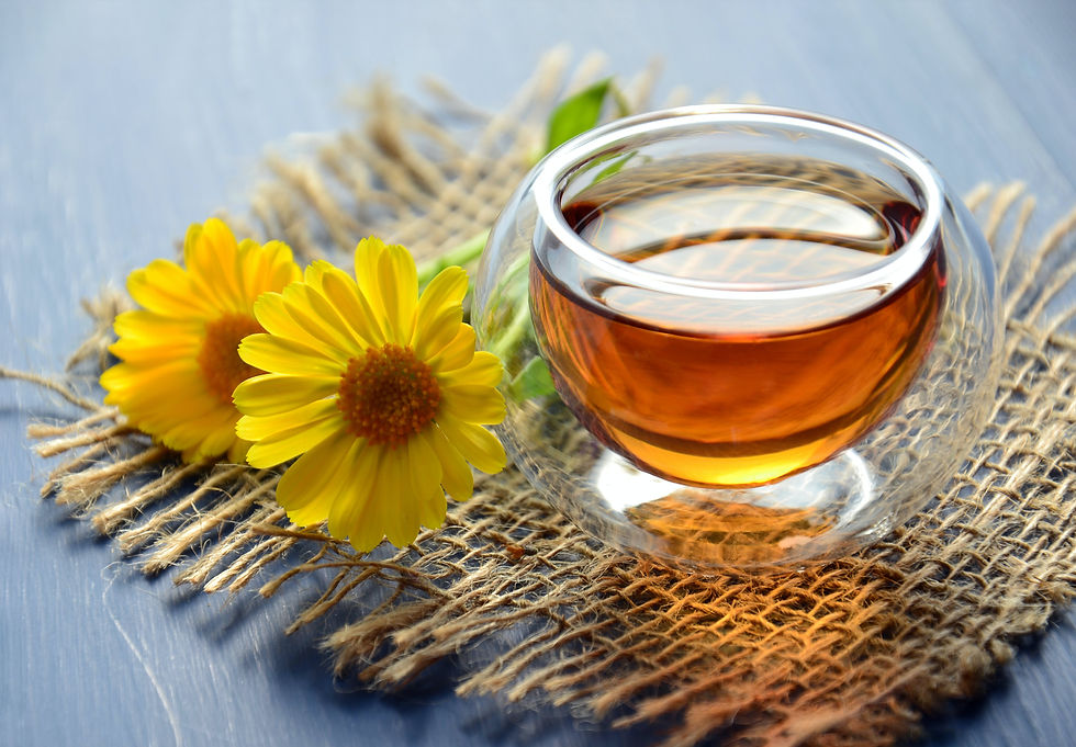 tea in glass cup next to flower