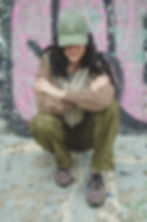 woman wearing Coastal Sun dad hat green sits against a pink and green wall