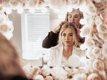 Bride in mirror having hair done sw wedding films