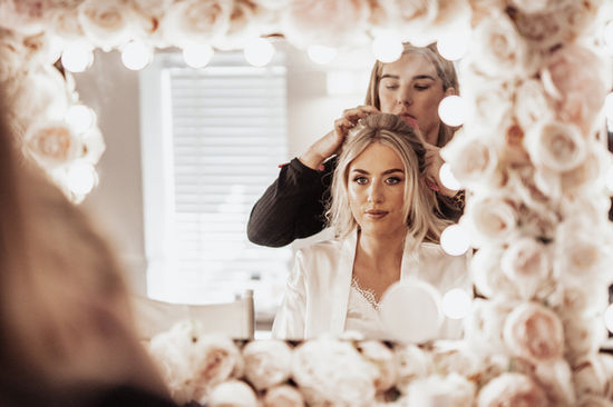 Bride in mirror having hair done sw wedding films