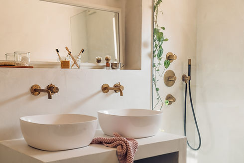 Fugenloses Bad, Waschtisch mit aufgesetzen Waschtbecken, Unterputzarmaturen, Dusche mit Unterputzgarnituren, Spiegel, Glasduschabtrennung, warme mediterrane Farbtöne, Garnituren in Kupferoptik