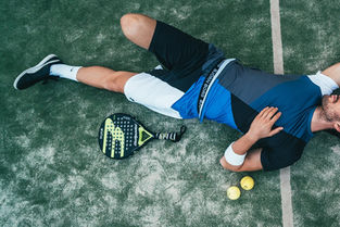 Pickleball player exhausted, laying on the Pickleball court with the bat and ball next to him