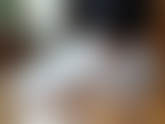 Close-up view of white Nike Air Force 1 shoe on wooden floor