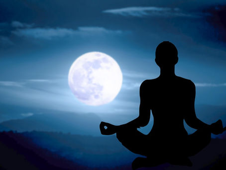 Silhouette of a person meditating, seated cross-legged, against a full moon in a serene night sky with clouds, evoking tranquility.