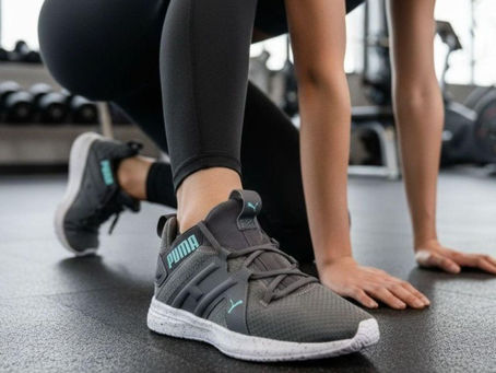 Woman kneeling on one knee in the gym wearing gym shoes
