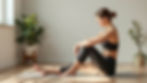 Woman in black workout attire sits on a yoga mat in a sunlit room. Plants in the background, serene and focused atmosphere.