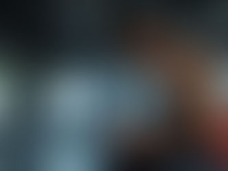 Guy with kettlebell sitting in a gym flexed.