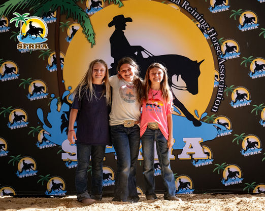 Three young girls posing and smiling in front of backdrop with SFRHA logo.