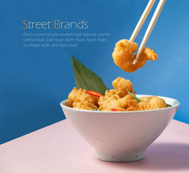 Food Photographer Dubai: chopsticks lifting crispy fried shrimp above a white bowl on a pink surface with a bold blue studio backdrop.