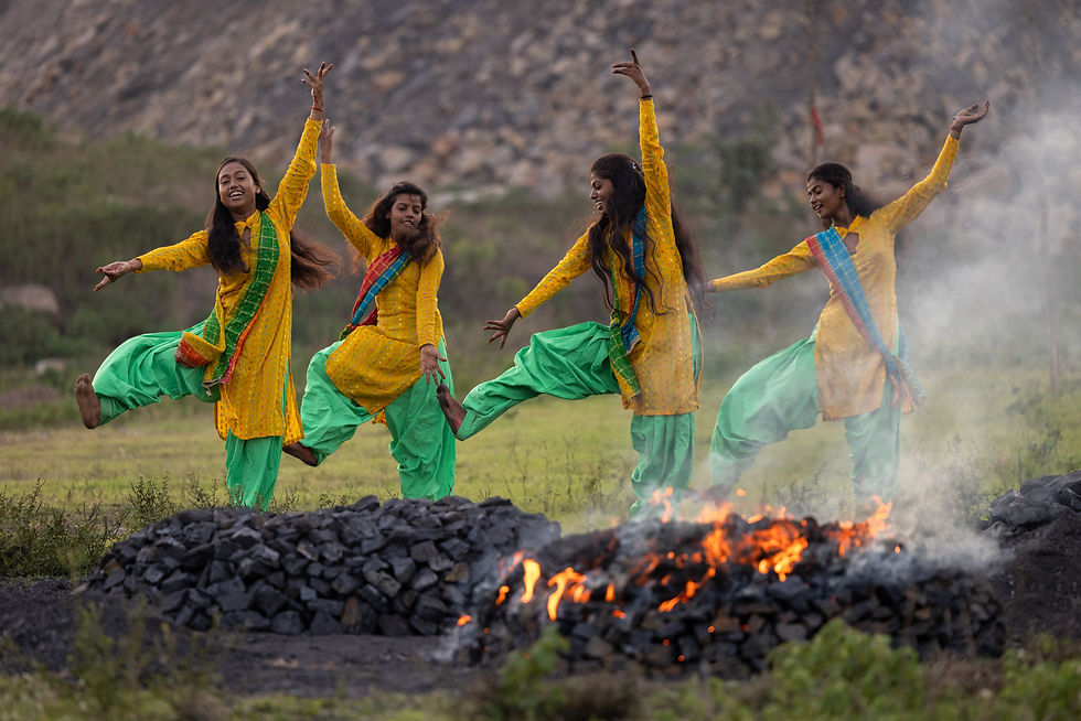 social documentary photography of rural girls dancing in yellow and green outfits beside smoky fire in open field