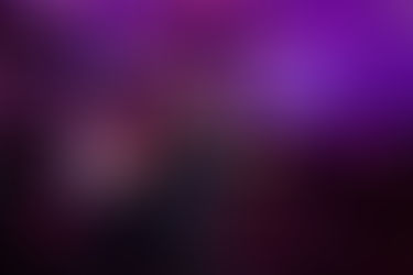 Event Photographer's Ideas – dramatic concert shot of male singer performing on stage with vibrant purple lights and live band behind him.