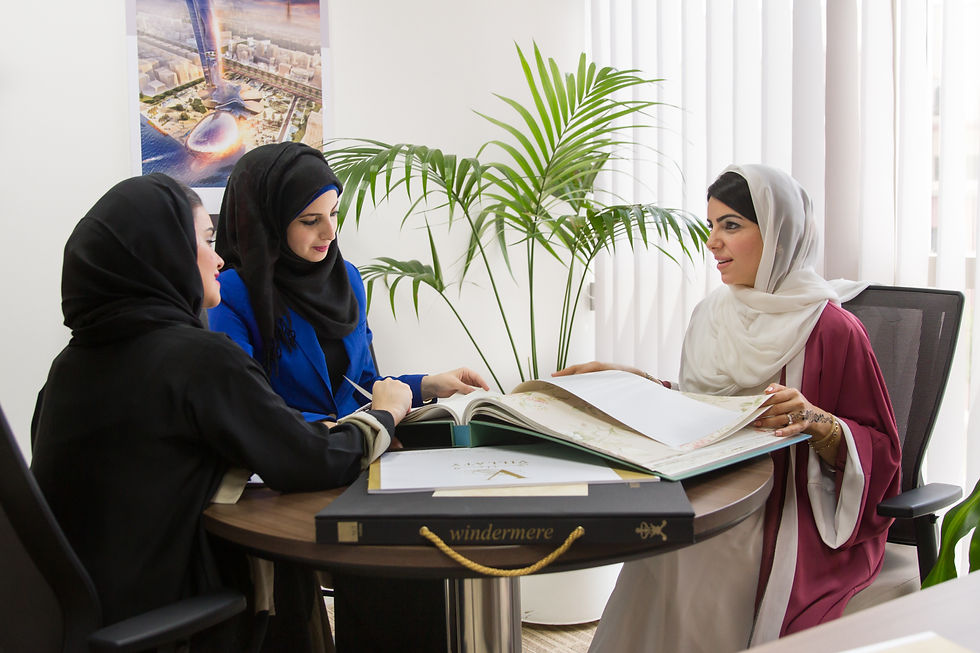 corporate headshots dubai showing three businesswomen in abayas and hijabs meeting with interior designer in bright modern office