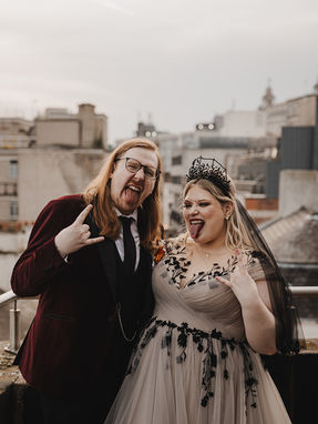 An alternative couple being edgy with devil horns, rock ' n' roll sign sticking iut their tongue
