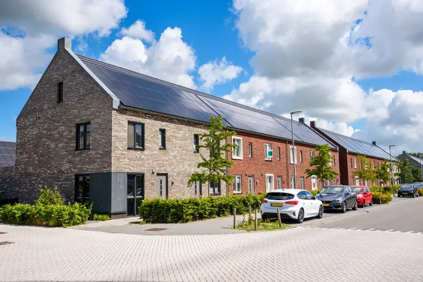 Eye-level view of a modern home equipped with solar panels and a heat pump