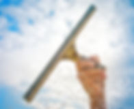 Hand cleaning window with blue sky and white clouds_edited.jpg