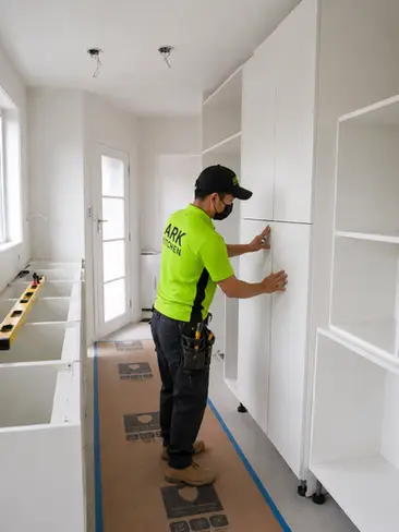 Kitchen installer fitting custom cabinetry during a kitchen renovation