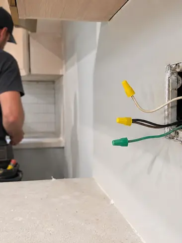 Electrician installing kitchen electrical services and appliance connections