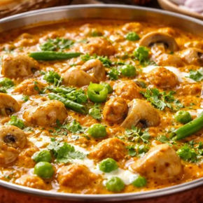 Restaurant style matar mushroom korma served in rich creamy gravy garnished with fresh cream and coriander