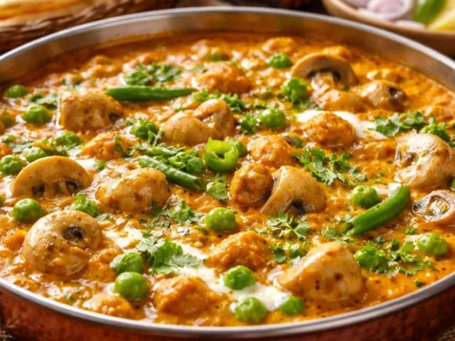 Restaurant style matar mushroom korma served in rich creamy gravy garnished with fresh cream and coriander