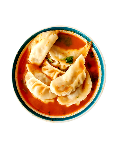 Momos in red spicy sauce served in a bowl.
