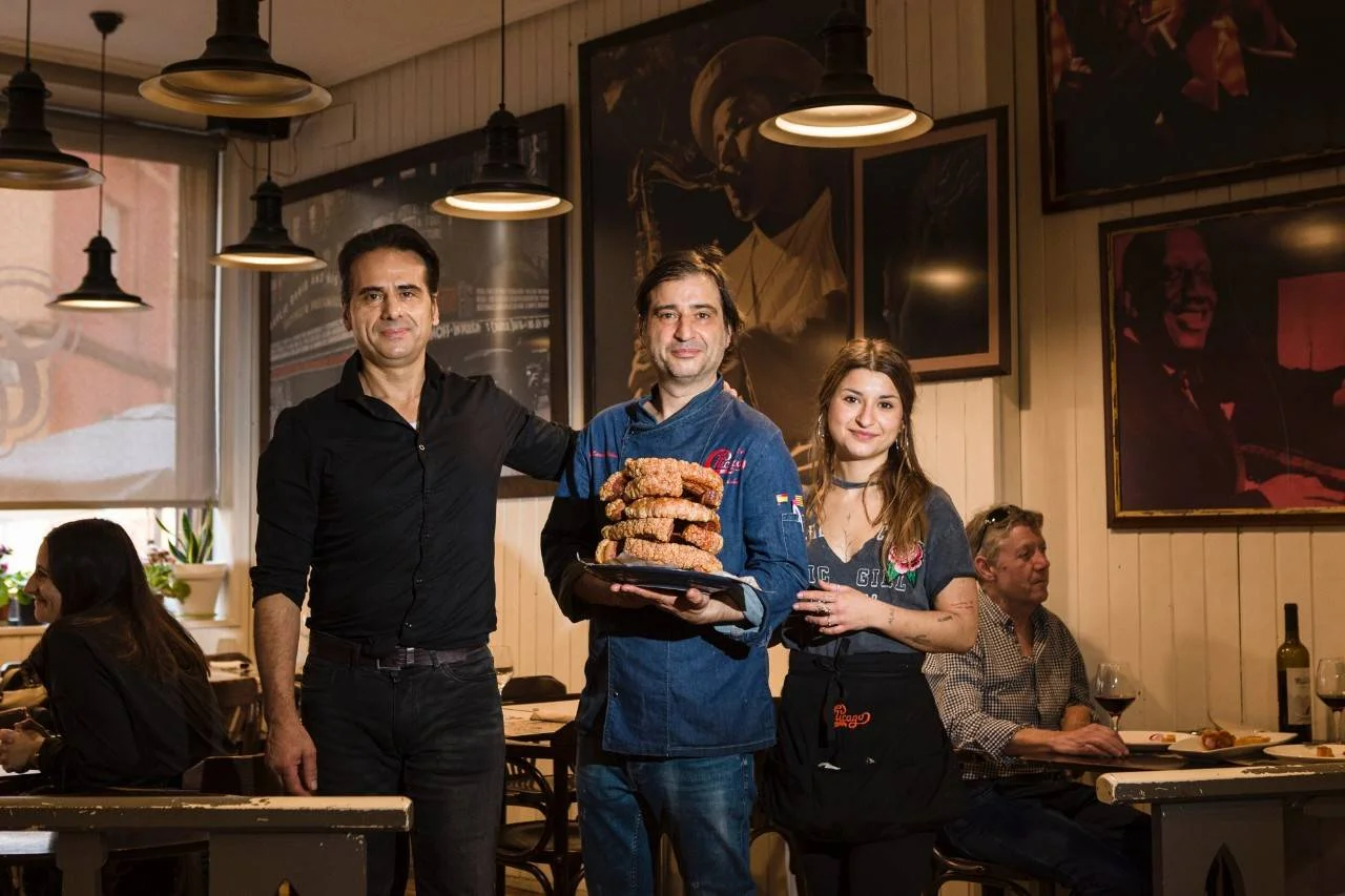 Interior del Café Chicago, con los dueños sosteniendo una pila de torreznos.
