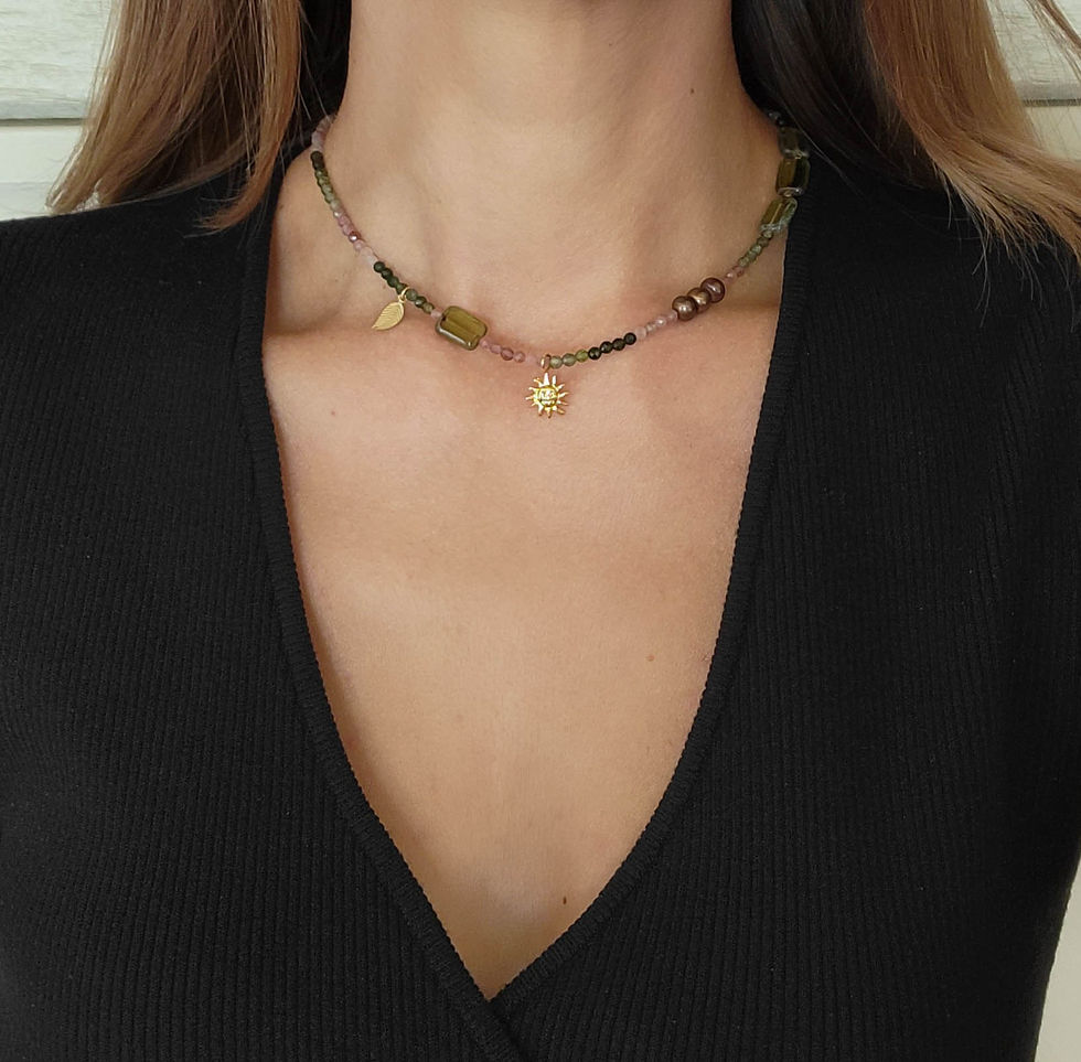 Multi-colored Tourmaline necklace with gold sun charm, on women's neck.