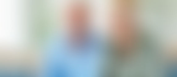 Ein älteres Paar lernt gemeinsam am Laptop, beide lächeln – Symbolbild für ChatGPT als Lernpartner und digitales Lernen im Alter.