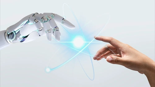 Eine menschliche Hand und eine Roboterhand berühren sich in einem Lichtpunkt. Symbolbild für die Verbindung zwischen Menschlichkeit, Technologie und ethischem Fortschritt.