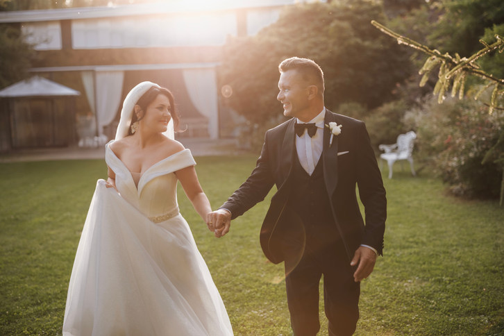 Fotograf ślubny Poznań- Uśmiechnięta para młoda na ślubnej sesji, trzymająca się za ręce. Oferta ślubna.