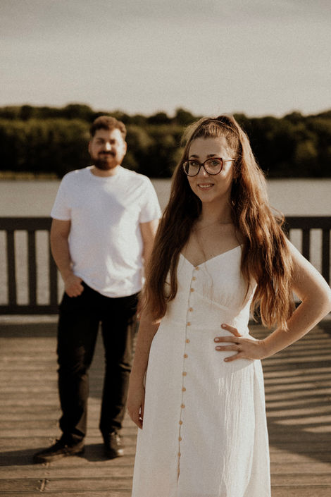 Uśmiechnięta Monika i Wiktor na pomoście nad jeziorem. Sesja narzeczeńska Jezioro Rusałka Kesja Stępka Fotografia