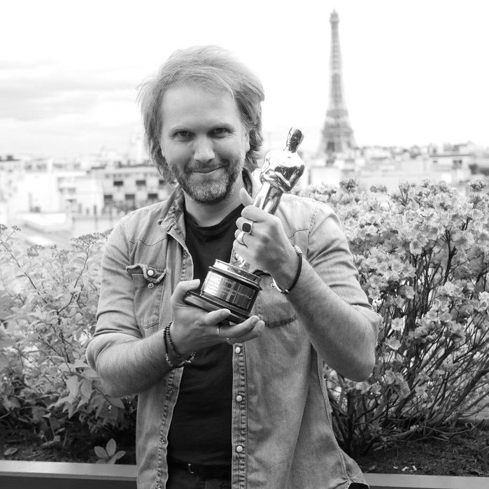 Man holding an award with the Eiffel Tower in the background