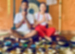 Deux instructeurs de yoga assis en tailleur, entourés de bols chantants.