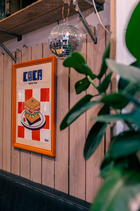 Affiche d'un sandwich sur mur en bois, avec boule disco.