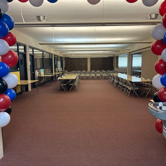 Room setup for graduation with red, white and blue balloons