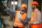 Two professionals discussing ADU construction on-site, highlighting collaboration and expertise in creating customized ADUs.