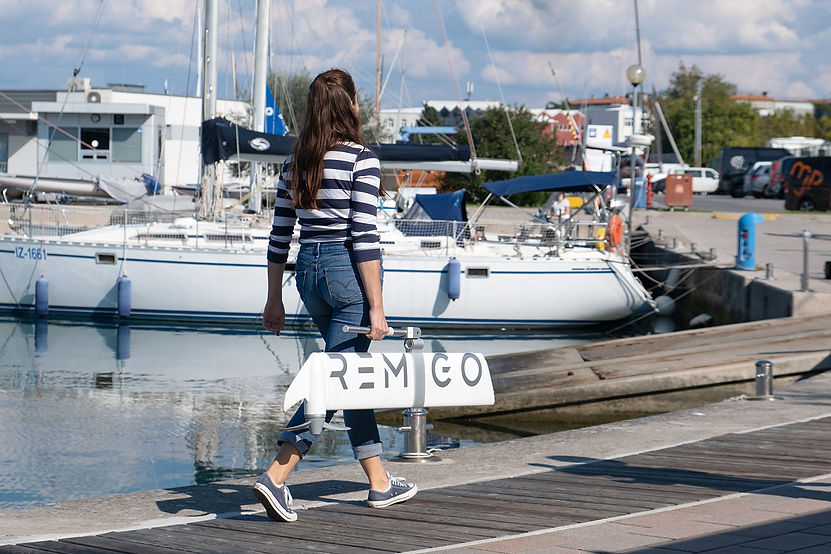 A lady carrying her Remigo electric outboard with ease down the pontoon.