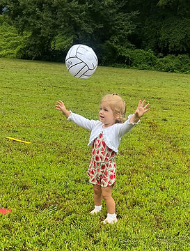 A young child setting a volleyball