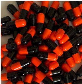 A pile of red and black capsules scattered on a surface. The colors are vivid, with a glossy texture, evoking a sense of abundance.
