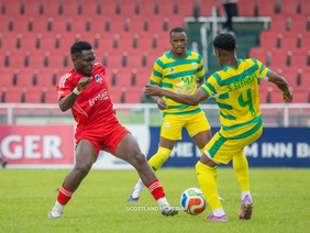 Two players challenging each other for the ball in a Scottland vs Hardbody match