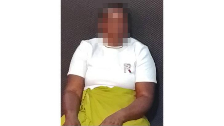 Woman silhouetted against a rural homestead — Hurungwe woman seeking help