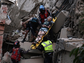 Rescue workers search collapsed buildings after Venezuela earthquake.