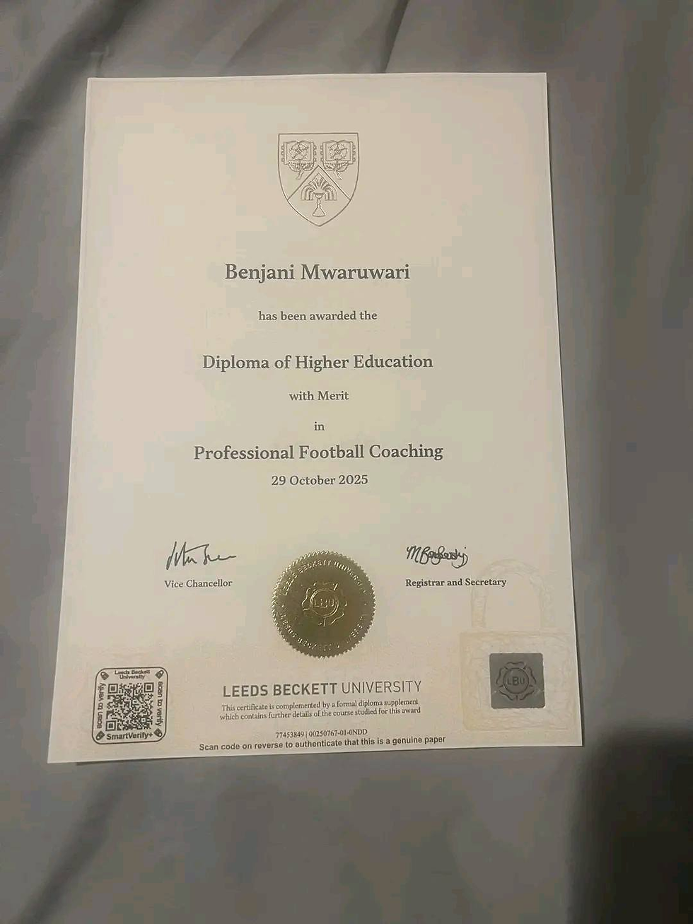Diploma with Leeds Beckett logo, awarded to Benjani Mwaruwari in Professional Football Coaching, 29 October 2025. Gold seal and signatures.